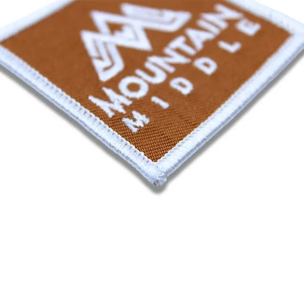 merrow border on orange embroidered patch with Mountain middle text