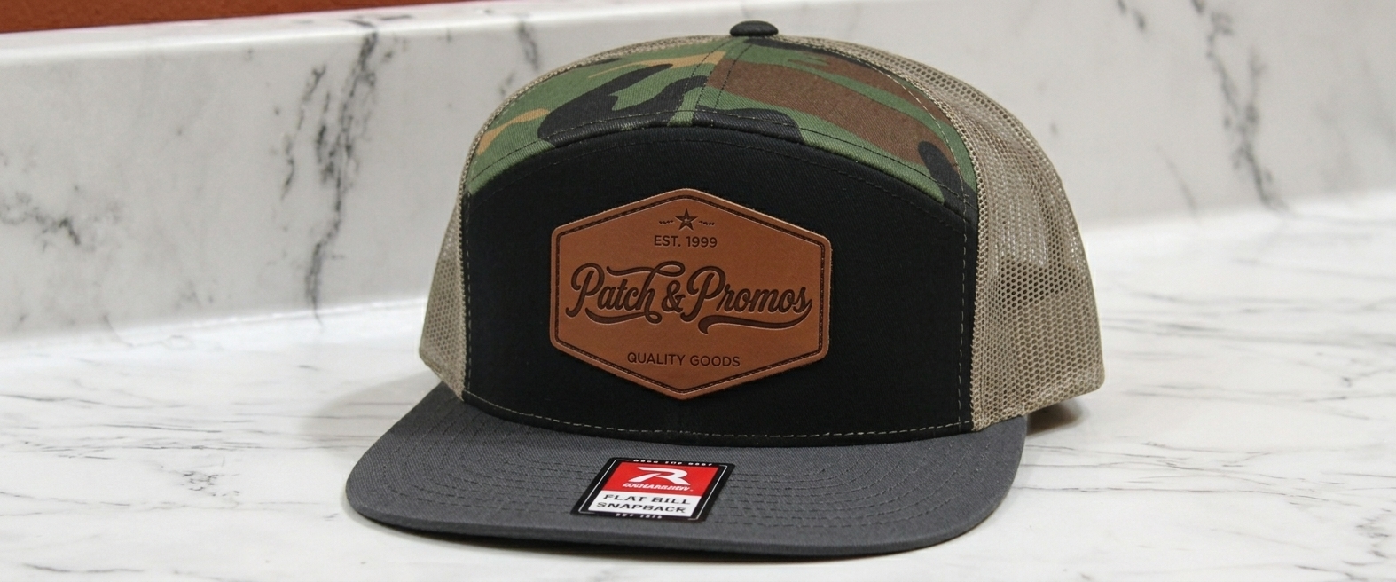 Custom Richardson camo trucker hat with embossed leather Patch & Promos hexagon patch